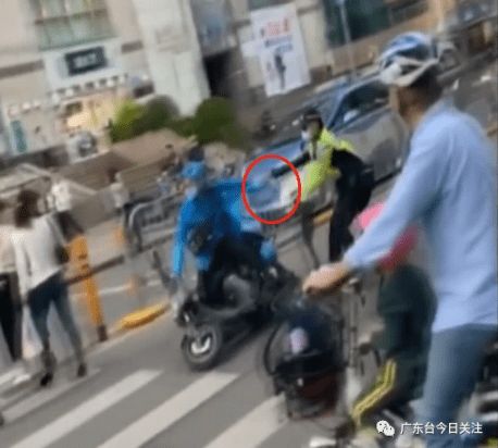 外卖小哥马路上逆行遭交警推拽连人带车摔倒